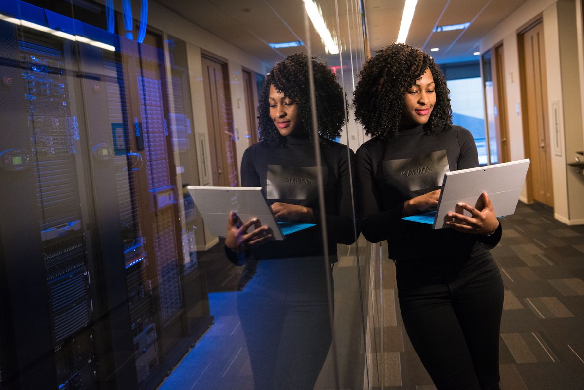Two engineers with laptops in a data center server aisle